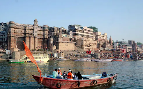 Boat on the Ganges River with Varanasi ghats in the background, India.