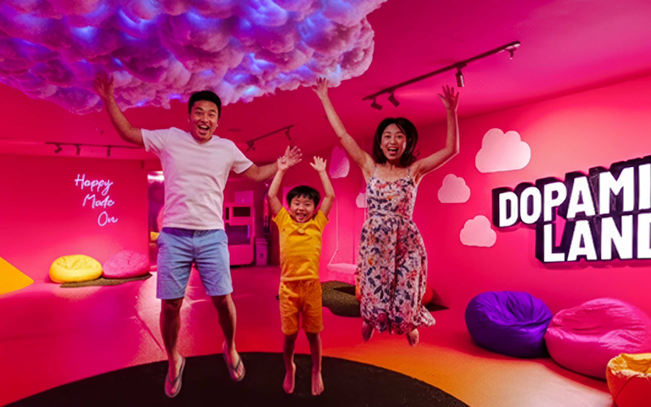 Family jumping in a colorful room at Dopamine Land multisensory experience.