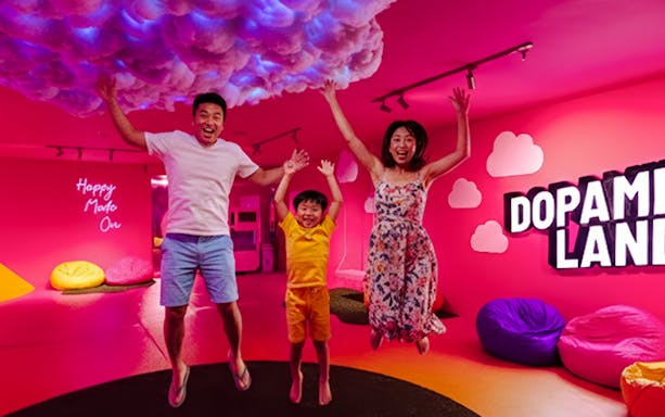Family jumping in a colorful room at Dopamine Land multisensory experience.