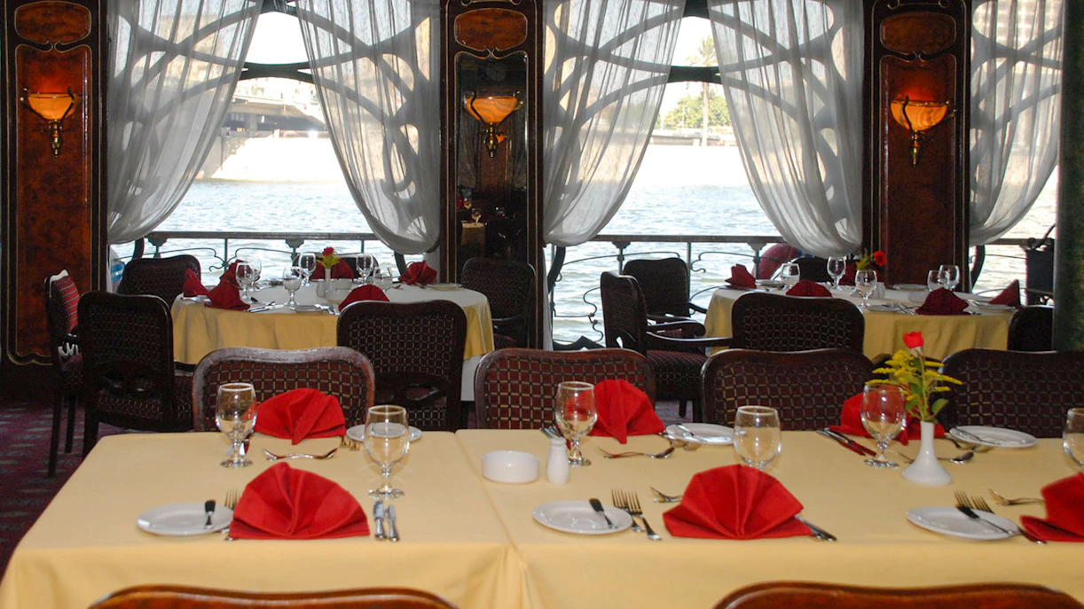 Dining tables set with red napkins on a Luxury Nile Dinner Cruise.