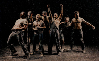 Actors performing a dramatic scene in The Outsiders on Broadway stage.