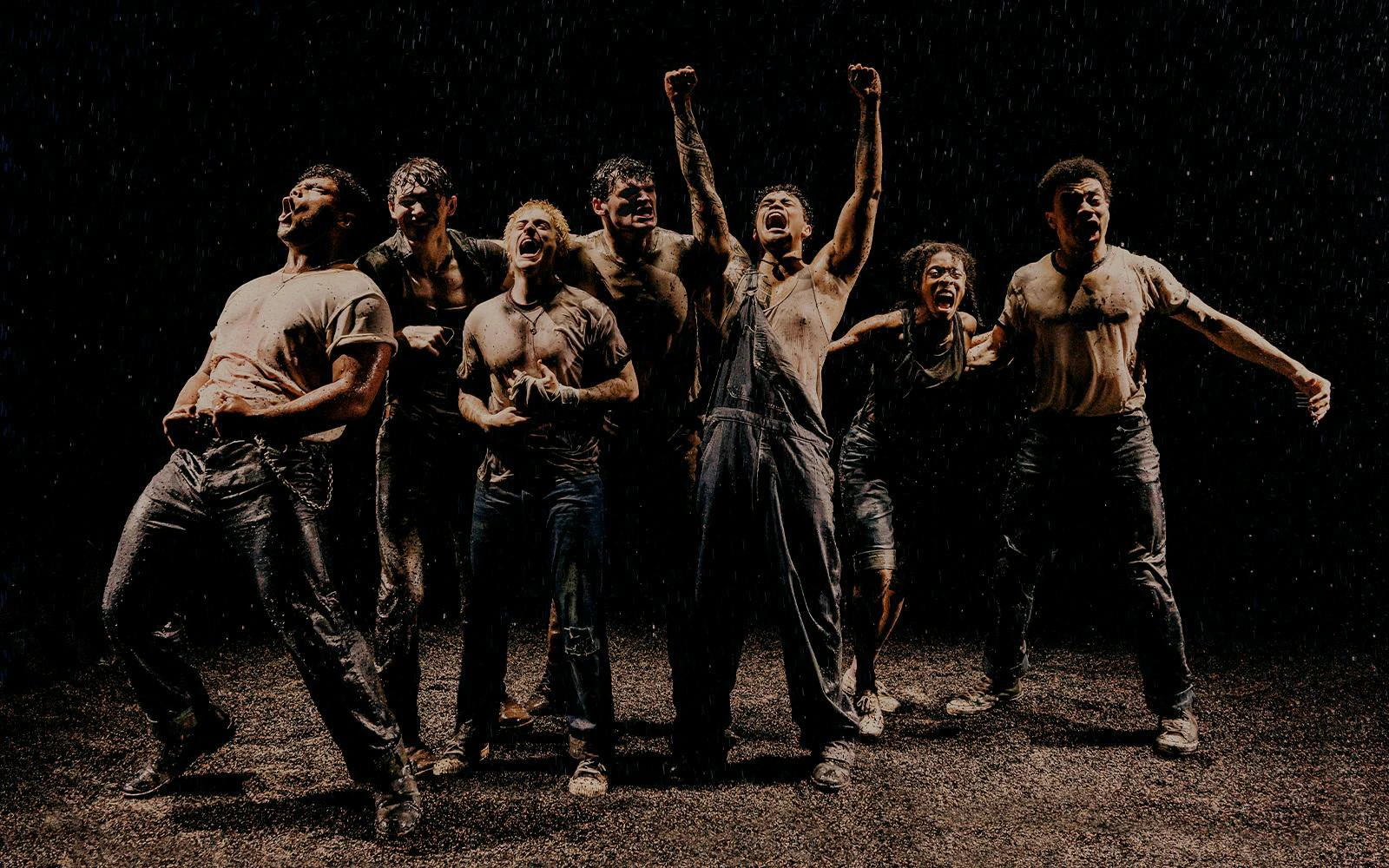 Actors performing a dramatic scene in The Outsiders on Broadway stage.