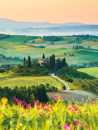 Tuscany landscape with cypress trees and farmhouse in San Quirico d'Orcia, Italy.