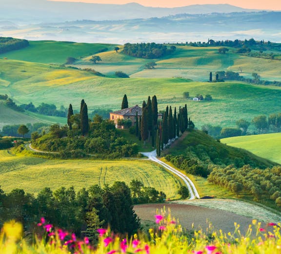 Tuscany landscape with cypress trees and farmhouse in San Quirico d'Orcia, Italy.