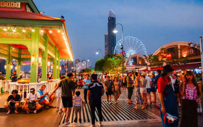 Tourists at Asiatique The Riverfront with Asiatique Sky Ferris wheel in Bangkok, Thailand.