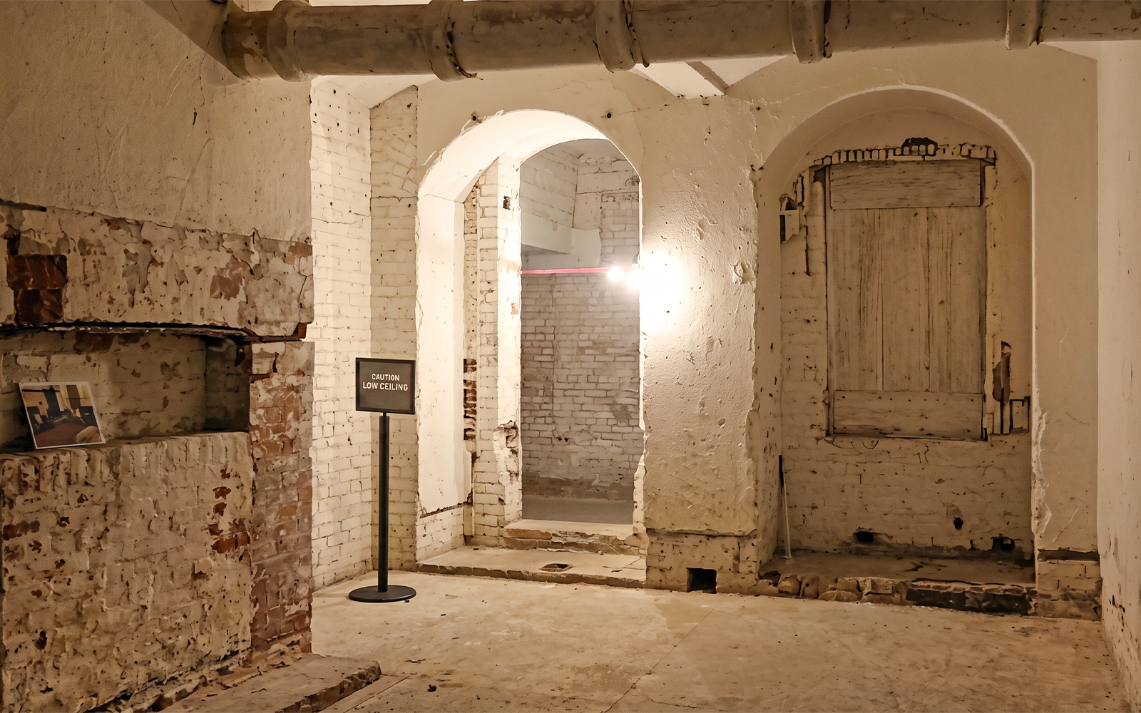 Behind the scenes tour area with low ceiling sign on Alcatraz Island.