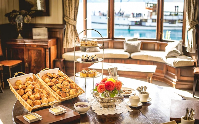 Tea and scones setup at Walter Peak High Country Farm with lake view in background.