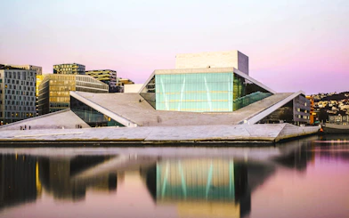 Oslo Opera House reflecting in the water at sunset, part of the Oslo Essential Highlights Tour.