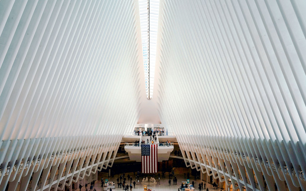 Interior view of The Oculus in New York City with people and American flag.