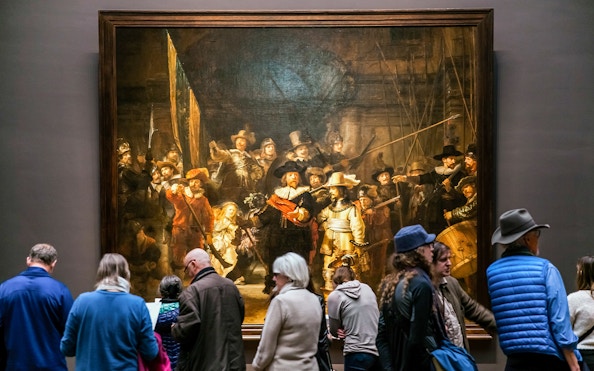 Visitors viewing 'The Night Watch' by Rembrandt at Rijksmuseum, Amsterdam.