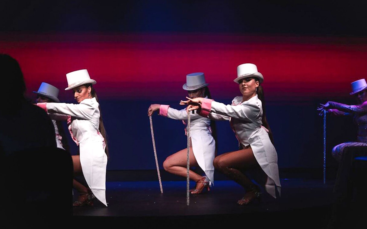 Cabaret dancers in white costumes performing at La Scène Dinner Show, Prague.