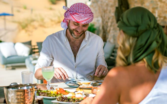 Two people enjoying a Michelin breakfast in the Dubai desert.