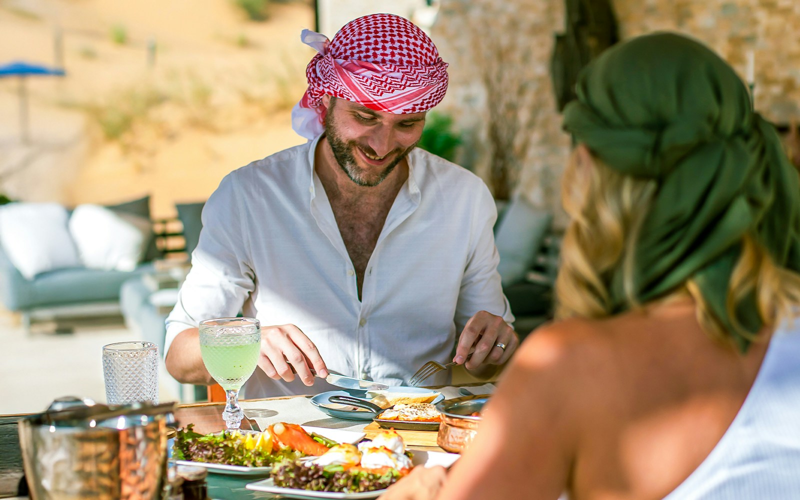 Two people enjoying a Michelin breakfast in the Dubai desert.
