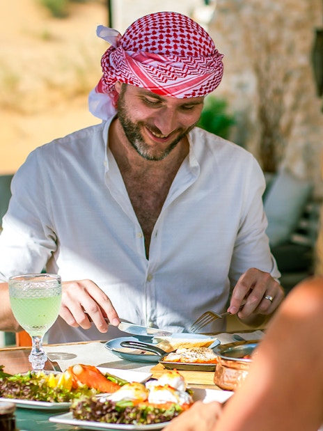Two people enjoying a Michelin breakfast in the Dubai desert.