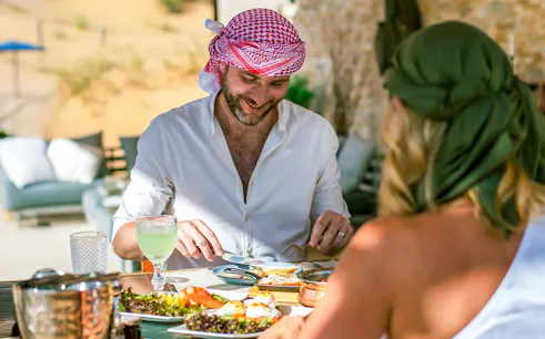 Two people enjoying a Michelin breakfast in the Dubai desert.