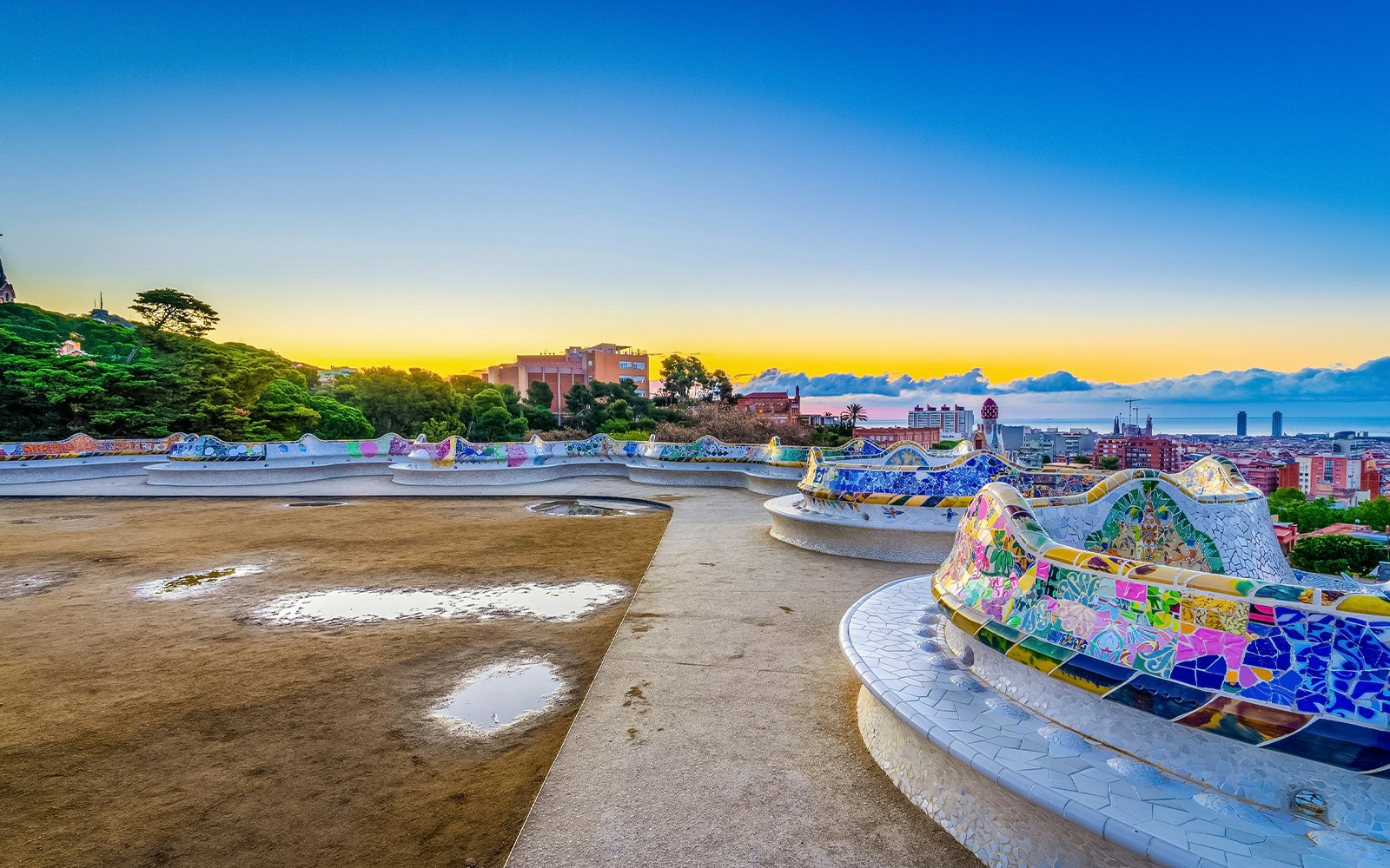 Colorful mosaic tiles and architectural structures in Park Güell, Barcelona.