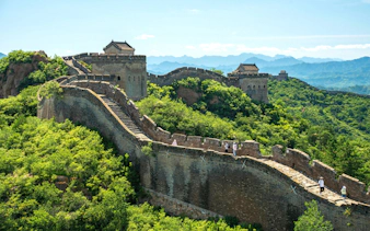 Great Wall of China winding through lush green hills, UNESCO World Heritage Site.