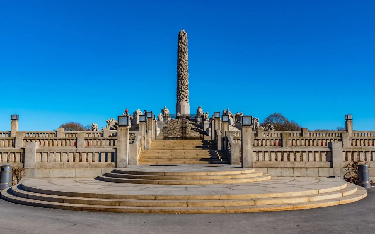 Vigeland Park's Monolith sculpture in Oslo under a clear blue sky.