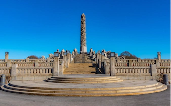 Vigeland Park's Monolith sculpture in Oslo under a clear blue sky.