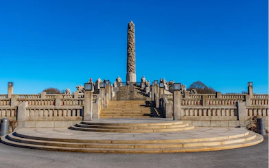 Vigeland Park's Monolith sculpture in Oslo under a clear blue sky.