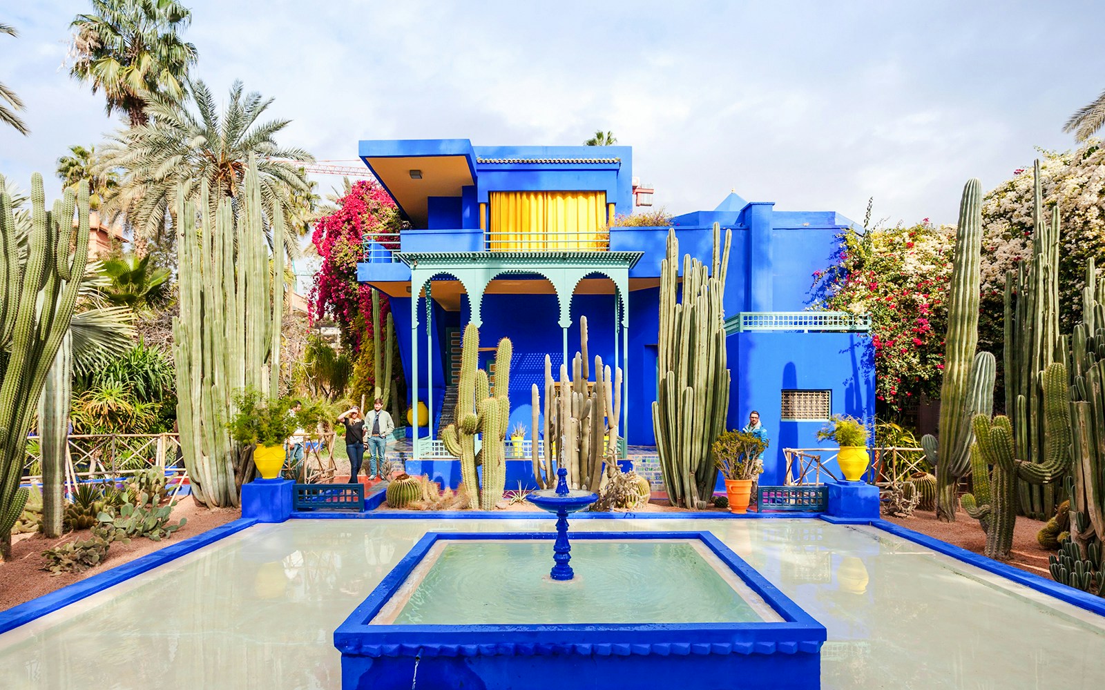 Jardin Majorelle's vibrant blue villa surrounded by cacti and palm trees in Marrakech.