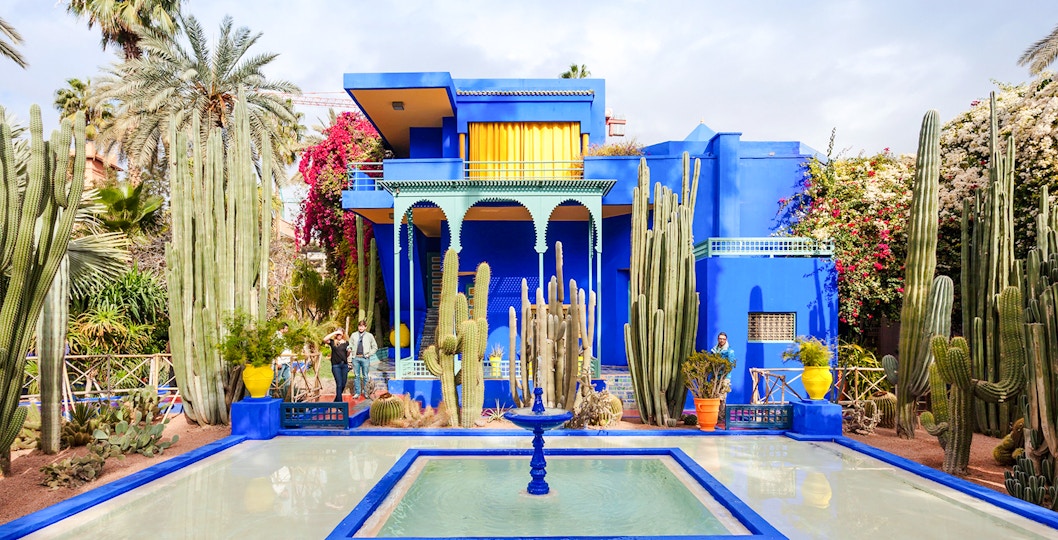 Jardin Majorelle's vibrant blue villa surrounded by cacti and palm trees in Marrakech.