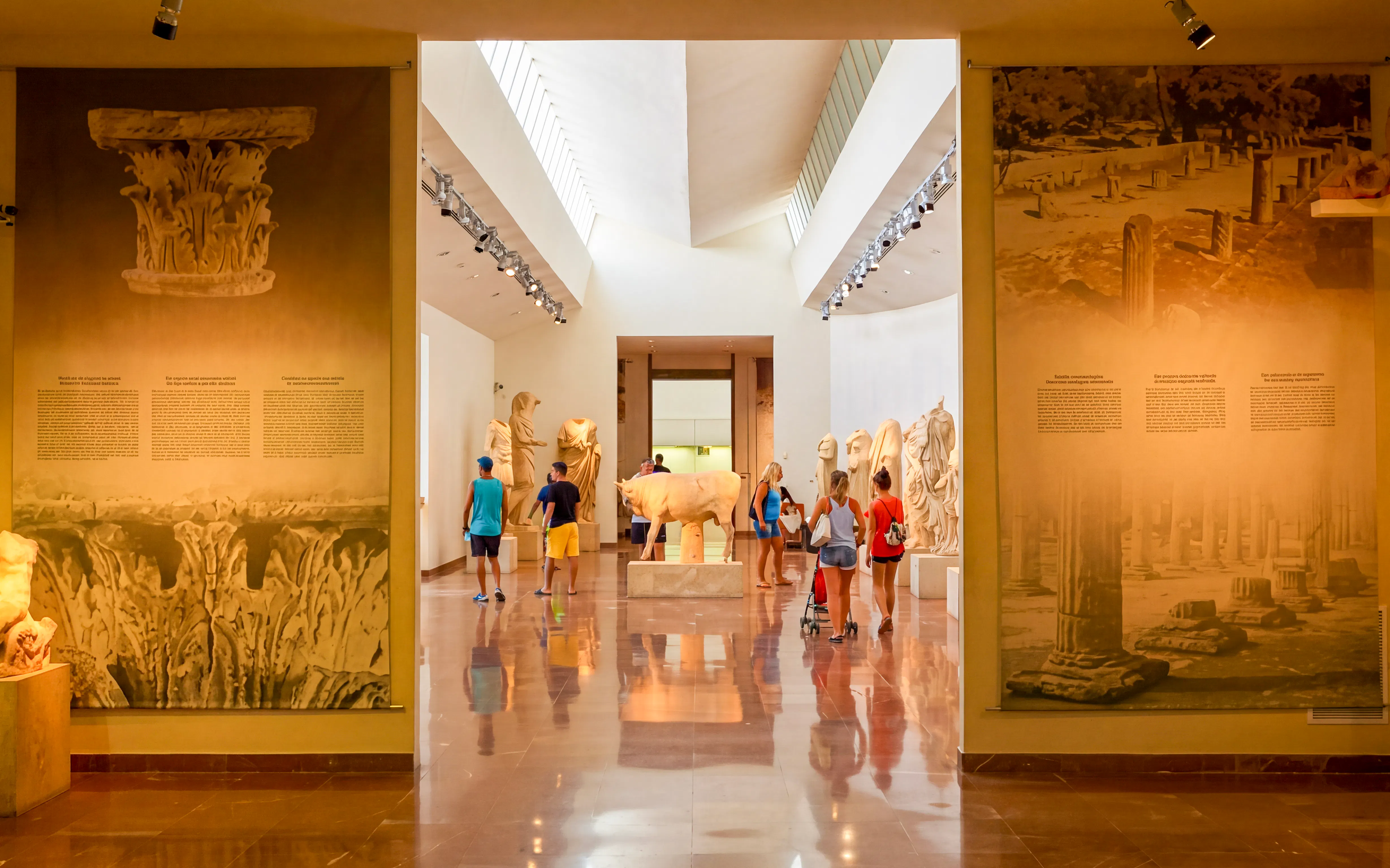Visitors exploring statues at the Archaeological Museum in Olympia.