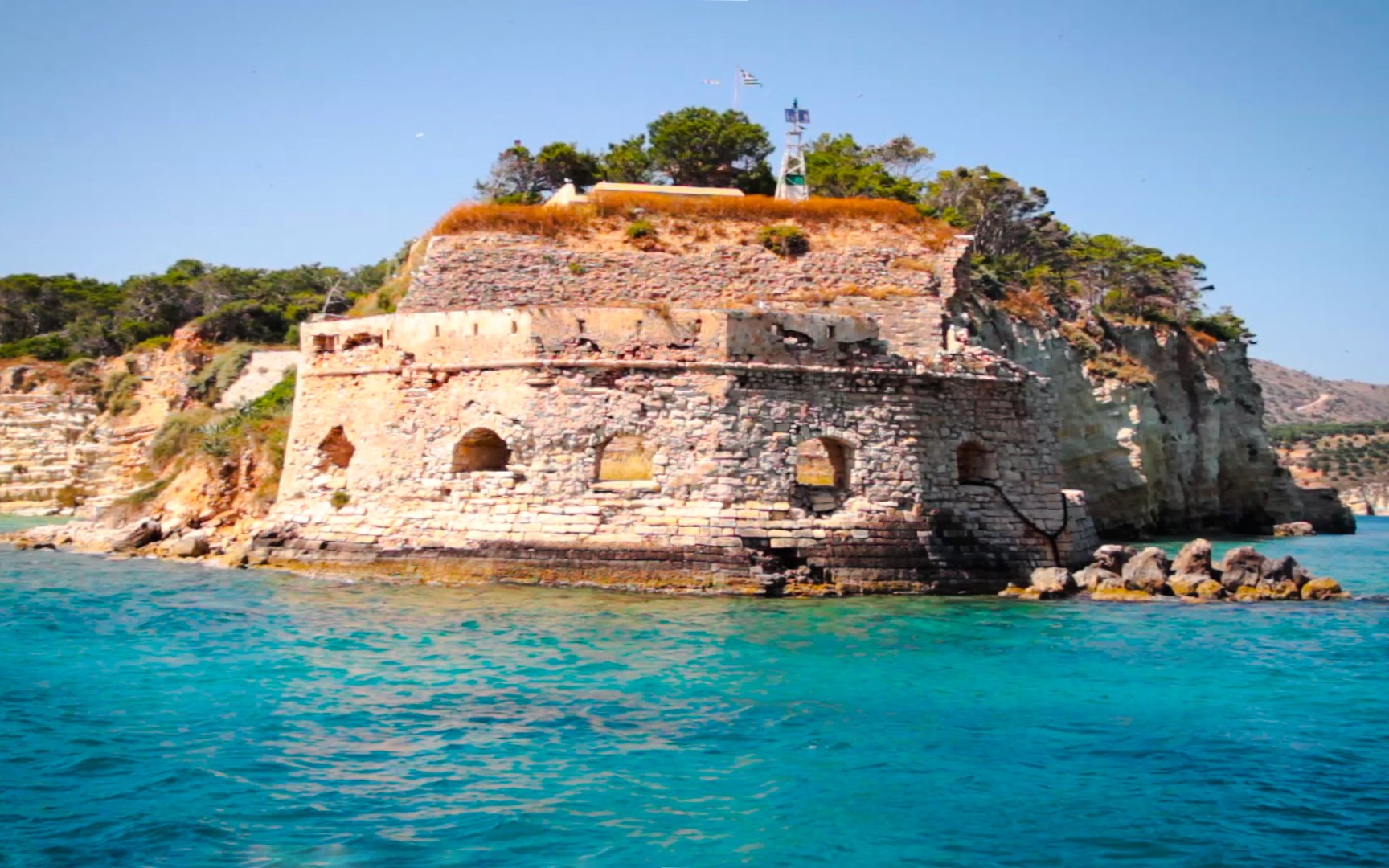 Venetian Fortress of Souda overlooking turquoise sea and rocky coastline.