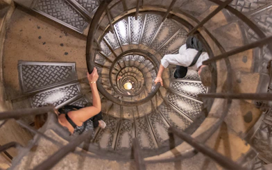 Visitors ascending spiral staircase to Arc de Triomphe rooftop, Paris.