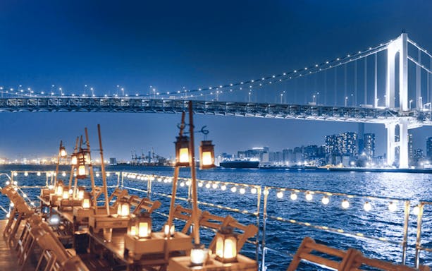 Dinner cruise on Tokyo Bay with Rainbow Bridge view during cherry blossom season.