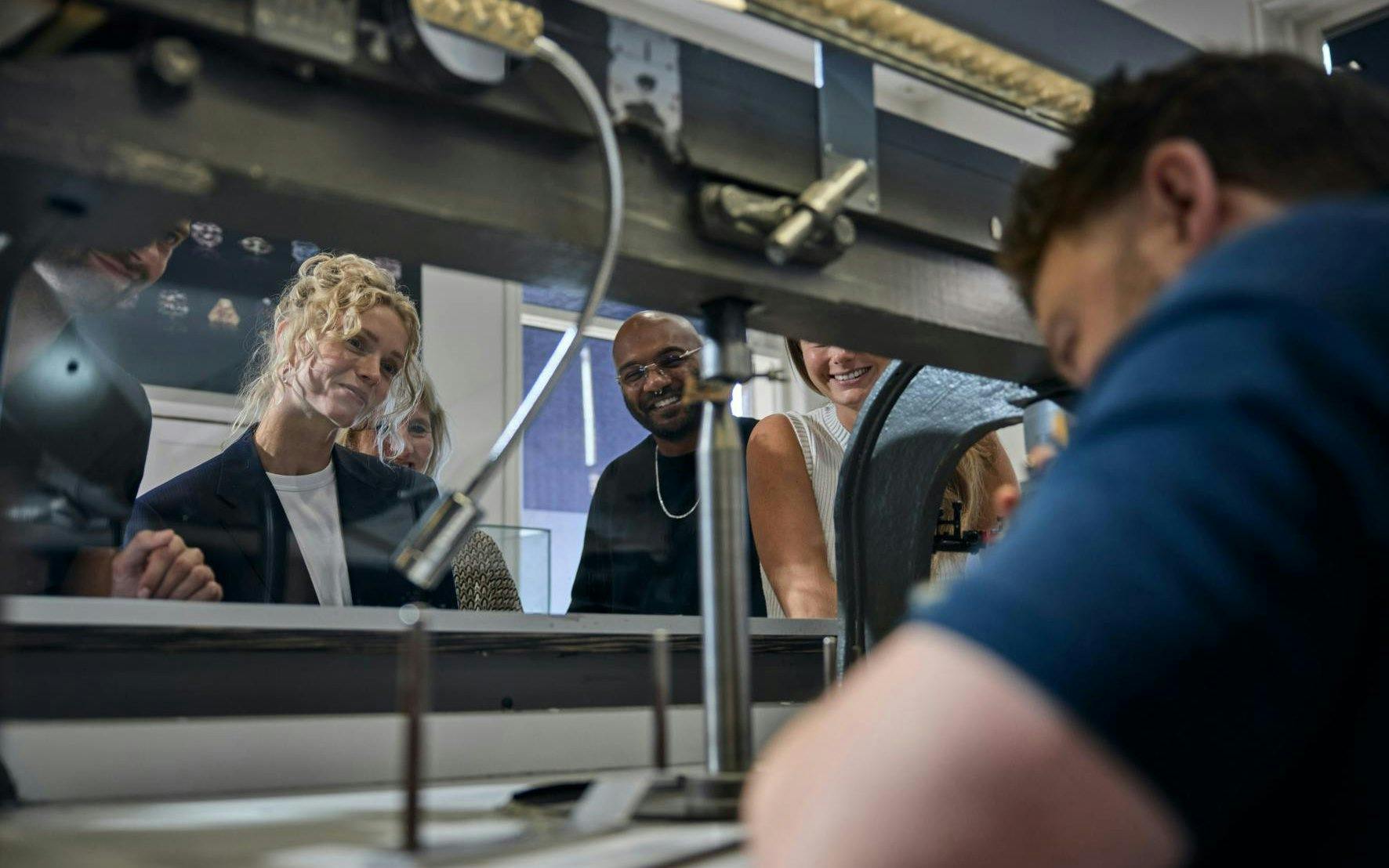 Visitors observing diamond cutting at Royal Coster Diamonds workshop.