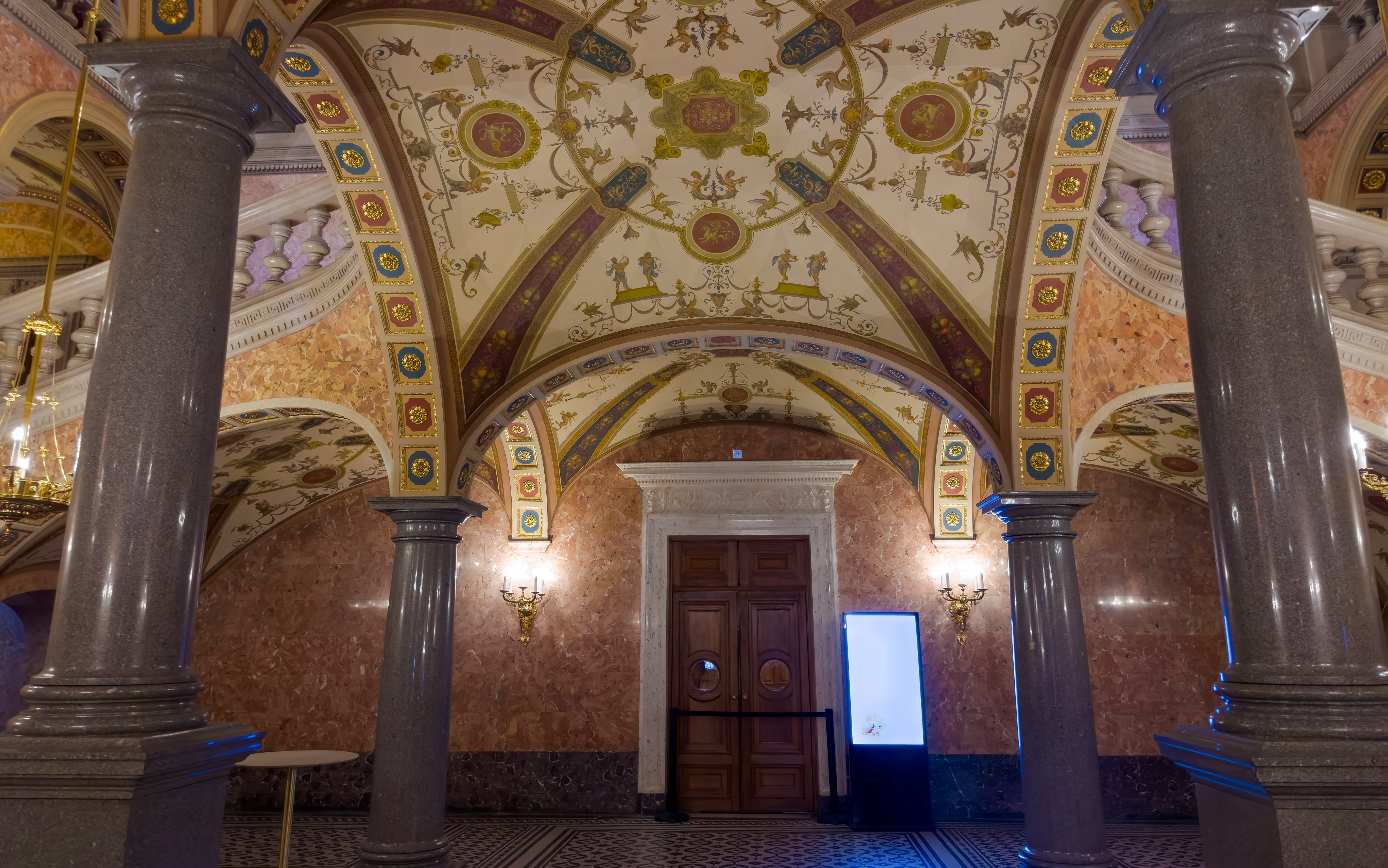 Foyer ceiling and columns of Hungarian State Opera House with ornate designs.