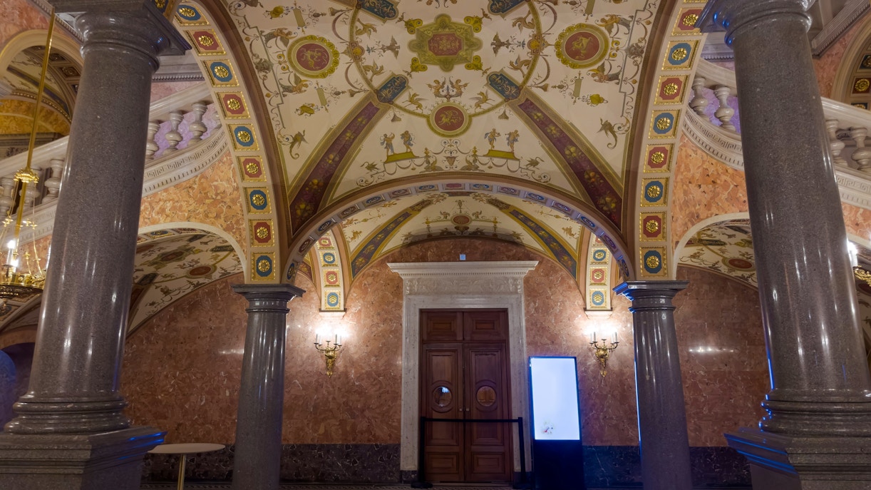 Foyer ceiling and columns of Hungarian State Opera House with ornate designs.
