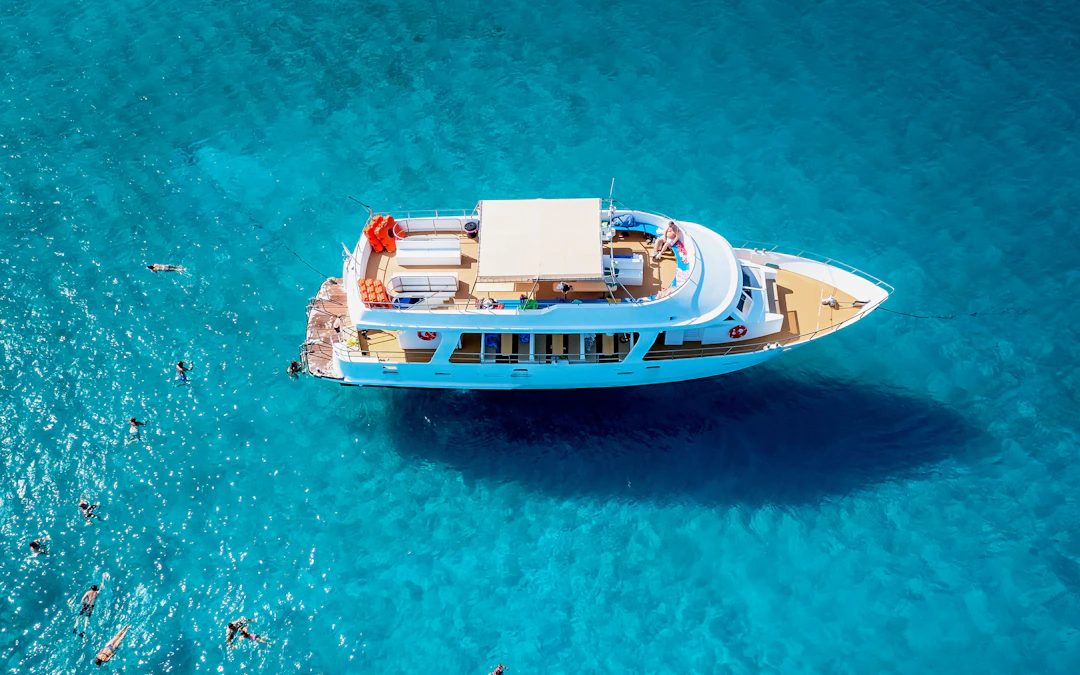 Cruise boat with swimming tourists in Blue Lagoon, Latchi, Paphos District, Cyprus.