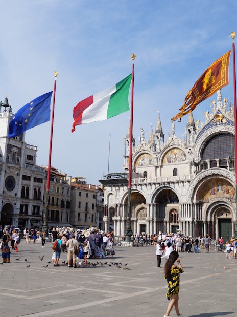 St. Mark's Basilica and flags in Venice's Piazza San Marco, Italy.