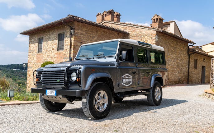 Land Rover parked in front of a stone villa in Tuscany for a wineland safari tour.