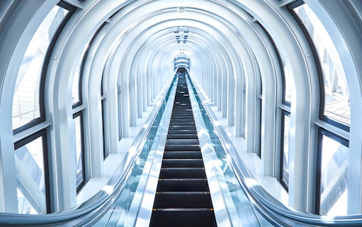 Escalator inside the Umeda Sky Building, Osaka, with a futuristic glass tunnel.