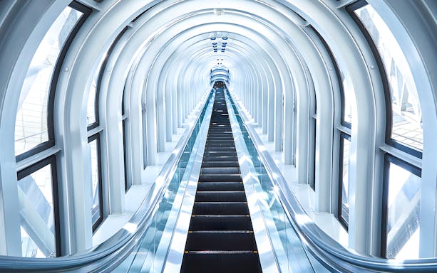 Escalator inside the Umeda Sky Building, Osaka, with a futuristic glass tunnel.