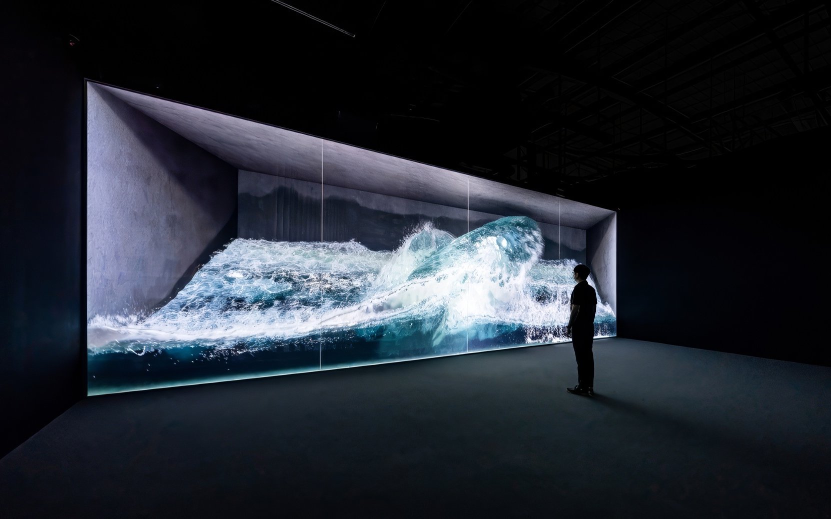 Digital wave installation at Arte Museum Jeju with a person observing.