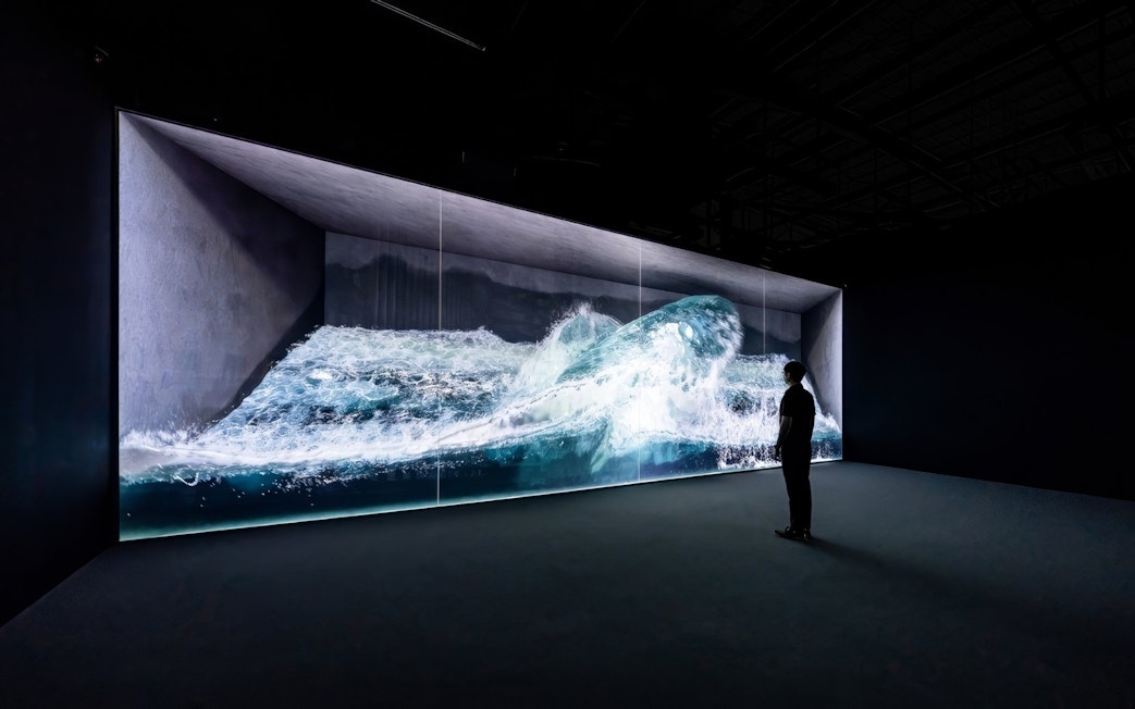 Digital wave installation at Arte Museum Jeju with a person observing.