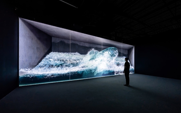 Digital wave installation at Arte Museum Jeju with a person observing.