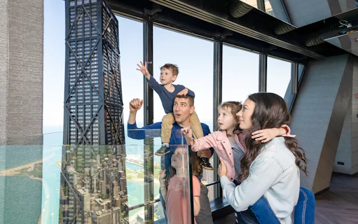 Family enjoying view from Chicago 360 Observation Deck with city skyline.