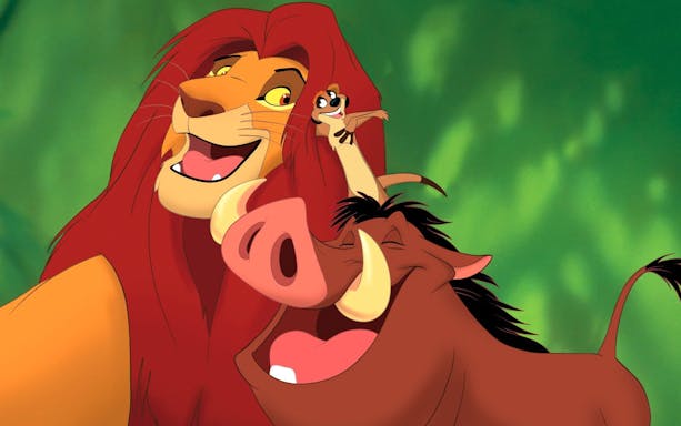 Simba, Timon, and Pumbaa smiling together in a scene from The Lion King.