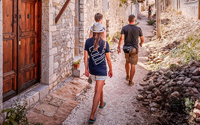 Guests walking through a narrow stone street in Berat's old town.