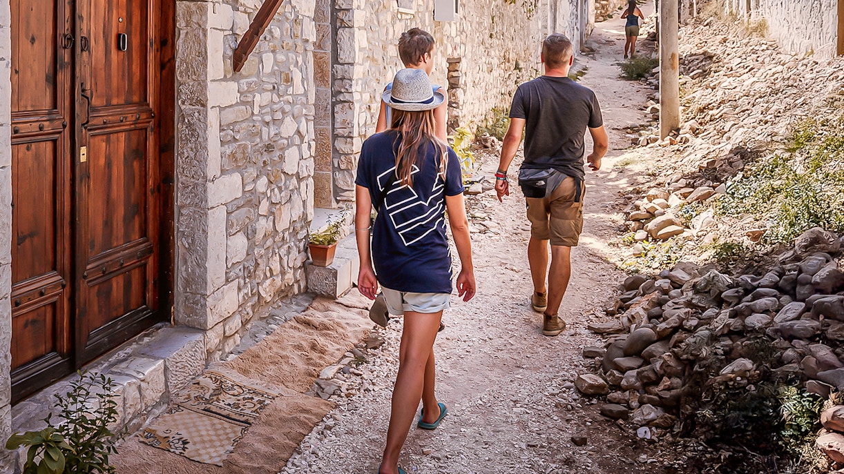 Guests walking through a narrow stone street in Berat's old town.