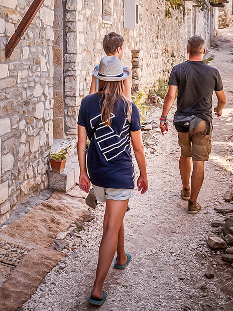 Guests walking through a narrow stone street in Berat's old town.