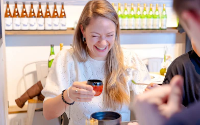Tourist enjoying matcha-making experience with Japanese sweets in Tokyo.