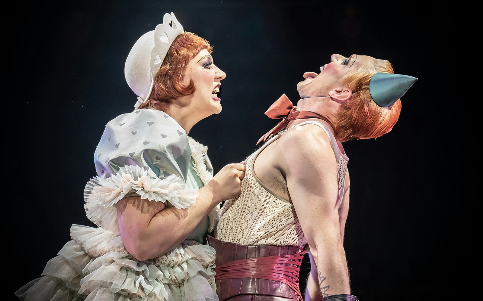 Performers in a lively cabaret show with theatrical costumes and expressions.