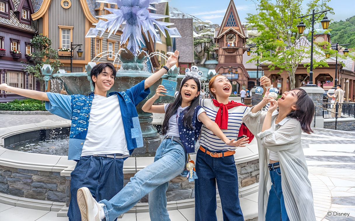 Friends enjoying at Disneyland Hong Kong near a themed fountain.