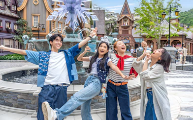 Friends enjoying at Disneyland Hong Kong near a themed fountain.
